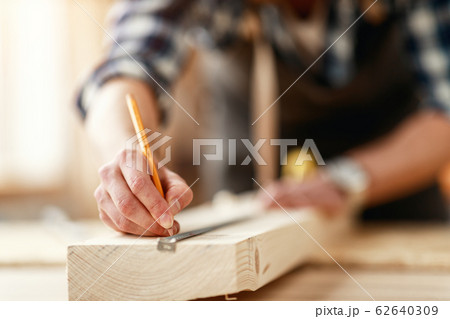 hands of master carpenter measure distance with 62640309
