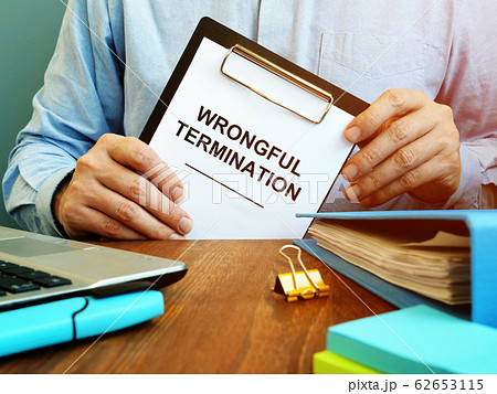 Employee holds papers about wrongful termination. 62653115