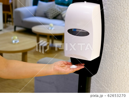 Closeup of Hands under the automatic alcohol 62653270