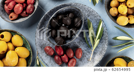 Olives flat lay panorama. Black, green and brown olives, shot from the top Olives flat lay panorama. Black, green and brown olives, shot from the top 62654995