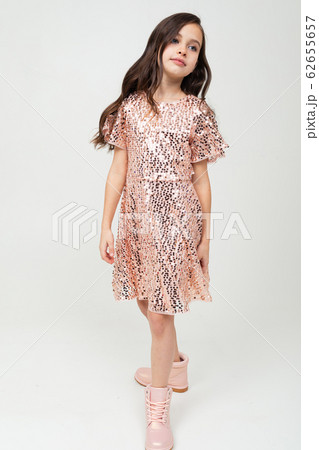 Full-length teenager girl in shiny party dress posing on a white studio background Full-length teenager girl in shiny party dress posing on a white studio background 62655657