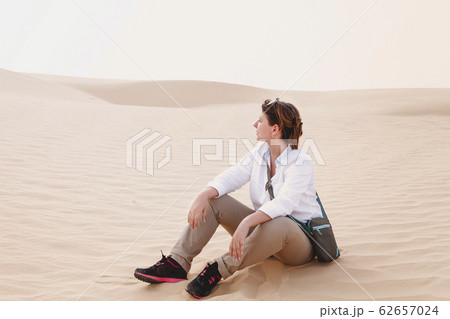 Calm woman sitting on sand 62657024