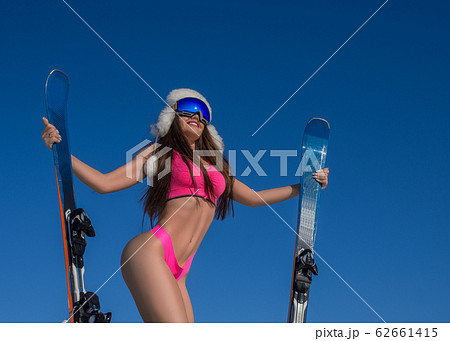 Winter portrait of a sexy woman with a ski on a mountain peak over blue sky background. Active lifestyle concept Winter portrait of a sexy woman with a ski on a mountain peak over blue sky background. Active lifestyle concept 62661415