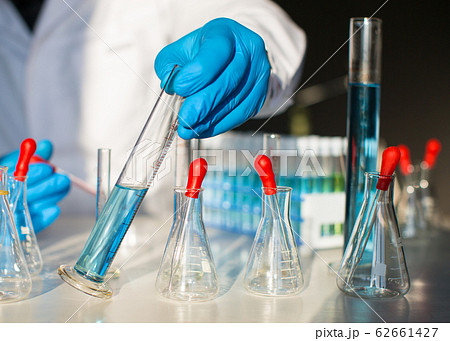 Researcher looking on blue liquid substance in test tube. 62661427