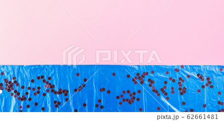 Plastic bag on pink with confetti. Sea pollution 62661481