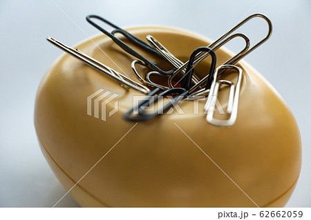 Paper clips in beige plastic oval box on white acrylic background, Close up & Macro shot, Business, Education, Stationery concept Paper clips in beige plastic oval box on white acrylic background, Close up & Macro shot, Business, Education, Stationery concept 62662059