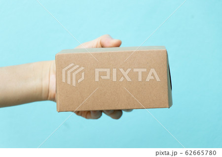 Woman hand hold the brown corrugated box on blue background  62665780