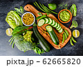 Flat lay assorted green toned vegetables on dark board, fresh organic raw food concept top view 62665820