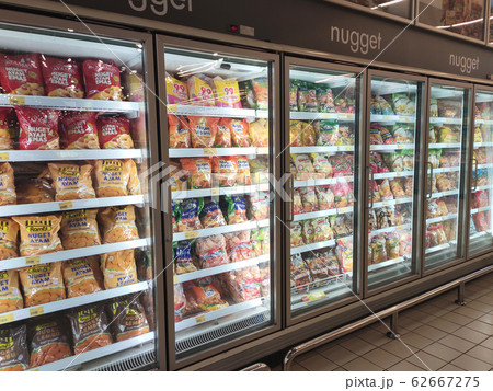 Frozen foods displayed on the rack inside the large chiller in the supermarket. Displayed and arranged by the brand to make easy for the customer to select.  62667275