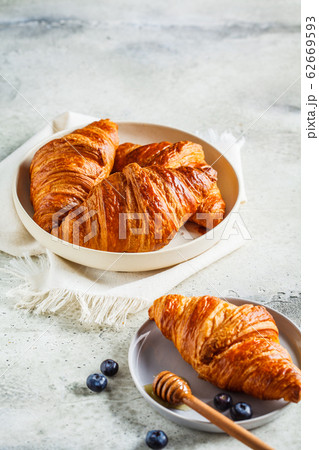 Fresh croissants with blueberries and honey 62669593