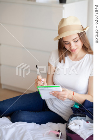 Beautiful woman collects clothes in travel suitcase on a trip 62672843