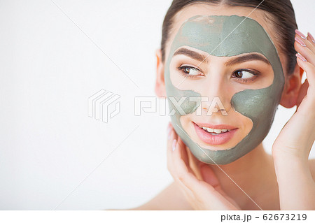 Skin Care. Young Woman With Cosmetic Clay Mask Holding Cucumber At Her Bathroom 62673219