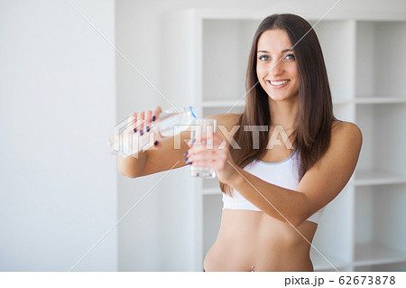 Young woman drinking water. Beautiful young girl holding bottle of water 62673878
