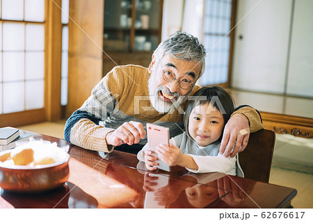スマホを使うおじいちゃんと孫 62676617