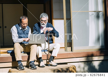 パソコンを見るシニア男性とその友人 62676841