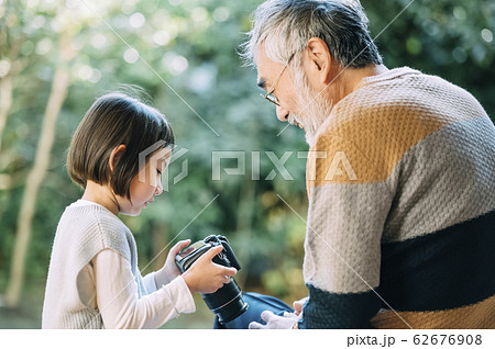 カメラを使うおじいちゃんと孫 カメラを使うおじいちゃんと孫 62676908