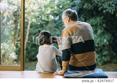 カメラを使うおじいちゃんと孫 62676917