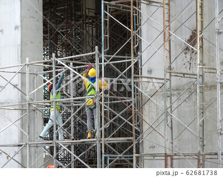 Construction workers working at height at the construction site. They are requested to wear appropriate safety gear to prevent bad happen to them. Construction workers working at height at the construction site. They are requested to wear appropriate safety gear to prevent bad happen to them. 62681738