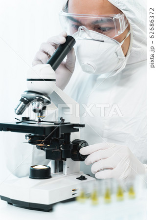 Concentrated young medical worker using modern microscope 62686372