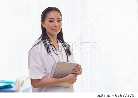 Portrait of woman doctor standing in Patient Room at hospital. looking at camera. Portrait of woman doctor standing in Patient Room at hospital. looking at camera. 62687279
