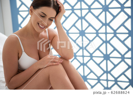 Happy smiling lady on couch in white underwear Happy smiling lady on couch in white underwear 62688624