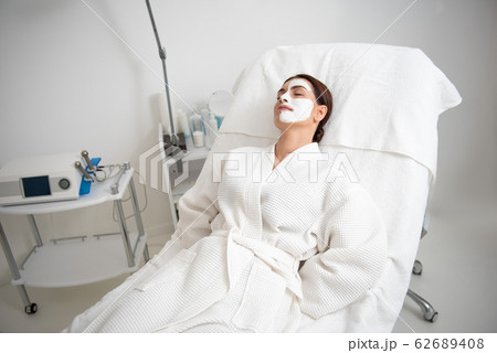 Young female resting on couch with face mask Young female resting on couch with face mask 62689408