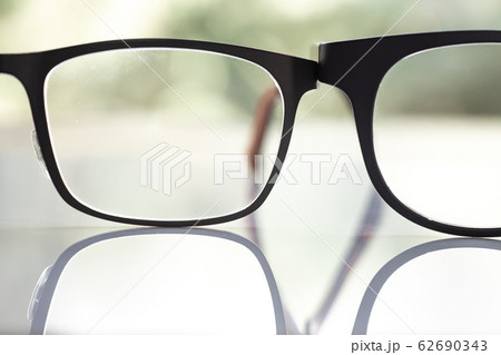 Two black shortsighted or nearsighted eyeglasses on white acrylic table, Bokeh green garden background, Close up & Macro shot, Selective focus, Reflection, Optical concept Two black shortsighted or nearsighted eyeglasses on white acrylic table, Bokeh green garden background, Close up & Macro shot, Selective focus, Reflection, Optical concept 62690343