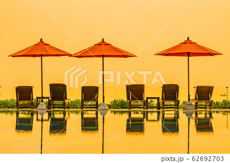 Beautiful sunrise around with umbrella and chair outdoor swimming pool Beautiful sunrise around with umbrella and chair outdoor swimming pool 62692703