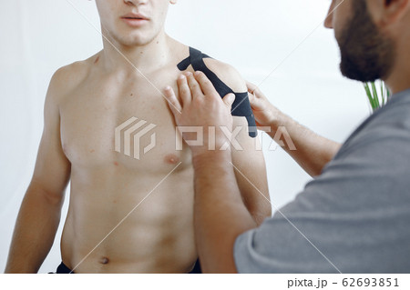 Doctor glues a tepee to an athlete at the hospital Doctor glues a tepee to an athlete at the hospital 62693851