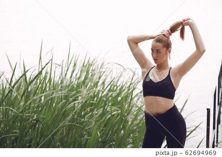 Beautiful sports girl in a summer park 62694969