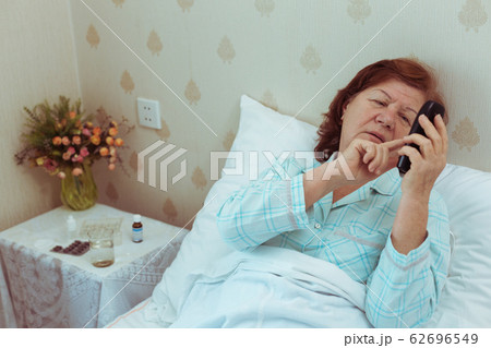 Sick elderly woman call ambulance, heart attack. Retired female feeling unwell and calling doctor. Sick elderly woman call ambulance, heart attack. Retired female feeling unwell and calling doctor. 62696549