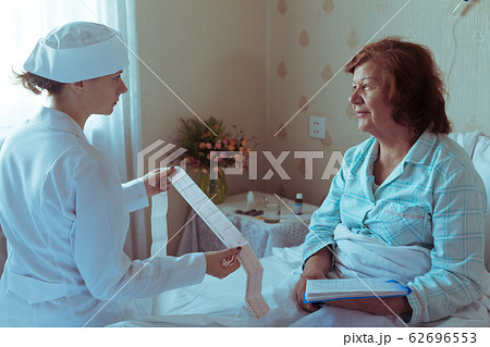 Doctor checking patient with cardiac disease.Elderly woman sitting in bed and listening the doctor Doctor checking patient with cardiac disease.Elderly woman sitting in bed and listening the doctor 62696553