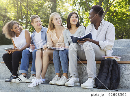 Friendly multiethnic students discussing new educational project Friendly multiethnic students discussing new educational project 62698562