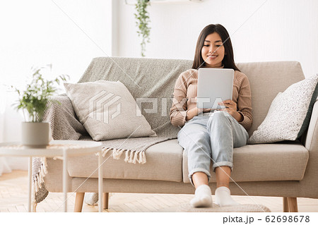 Asian teen girl surfing internet on digital tablet Asian teen girl surfing internet on digital tablet 62698678