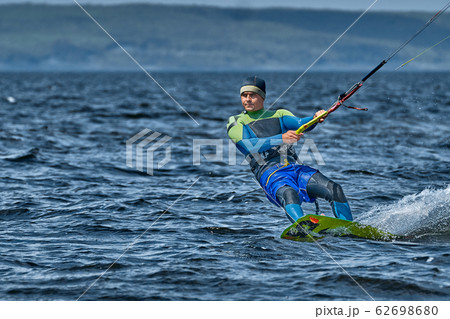 A male kiter slides on the surface of the water. 62698680