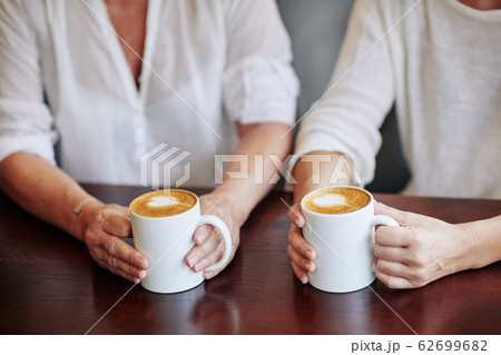 Mother and daughter drinking cappuccino - Stock Photo [62699682 