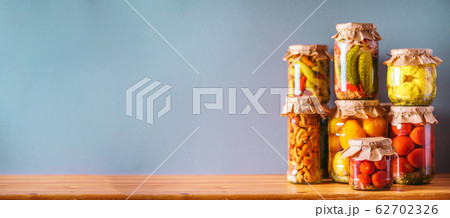 Сucumber, squash and tomatoes pickling and canning into glass jars. Ingredients for vegetables preserving. Healthy fermented food concept. Harvest storing Сucumber, squash and tomatoes pickling and canning into glass jars. Ingredients for vegetables preserving. Healthy fermented food concept. Harvest storing 62702326