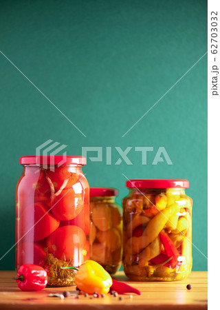 Сucumber, squash and tomatoes pickling and canning into glass jars. Ingredients for vegetables preserving. Healthy fermented food concept. Harvest storing 62703032