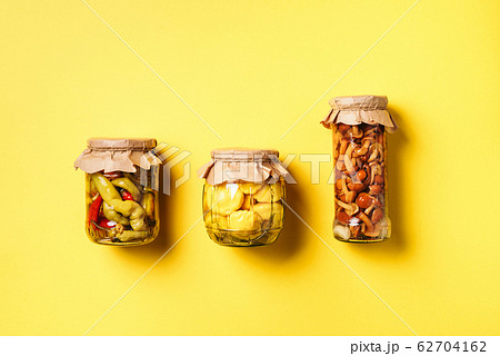 Сucumber, squash and tomatoes pickling and canning into glass jars. Ingredients for vegetables preserving. Healthy fermented food concept. Top view. Copy space. Сucumber, squash and tomatoes pickling and canning into glass jars. Ingredients for vegetables preserving. Healthy fermented food concept. Top view. Copy space. 62704162