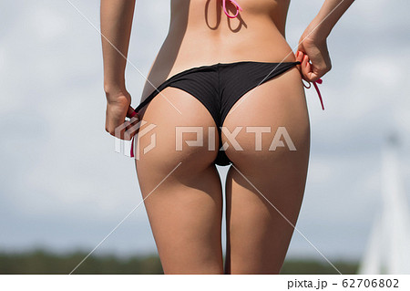 Fit hot woman taking off swimsuit panties - Stock Photo [71225890