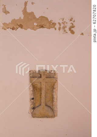 Stone cross in a wall of a building Stone cross in a wall of a building 62707820