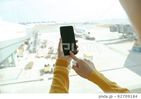 Woman hand hold smartphone at airport Woman hand hold smartphone at airport 62709184
