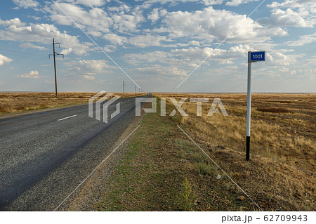 empty road in the steppe and kilometer sign 1001 62709943