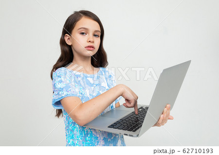 charming girl made an order for an educational course via the Internet using a laptop on a white 62710193