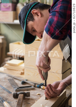 Carpenter working with a chisel 62710629