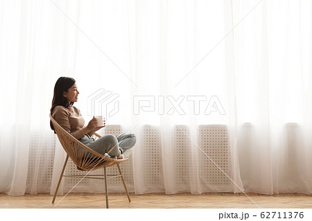 Tea time. Relaxed girl sitting in modern chair Tea time. Relaxed girl sitting in modern chair 62711376