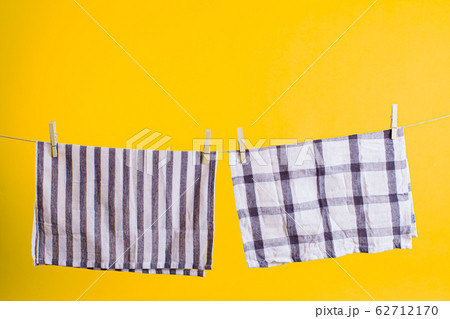 Eco friendly household items. Washed towels with wooden clothespins hanging on the rope Eco friendly household items. Washed towels with wooden clothespins hanging on the rope 62712170