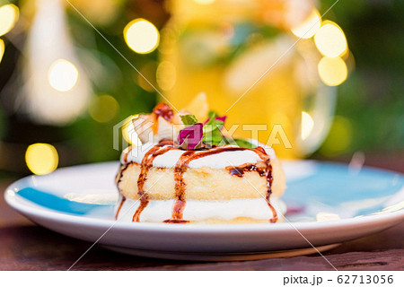 Cottage cheese pancakes or syrniki with cream, fruit jam and flower decoration 62713056