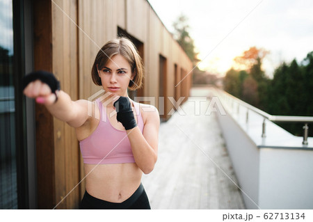 A young woman practising karate outdoors on terrace. A young woman practising karate outdoors on terrace. 62713134