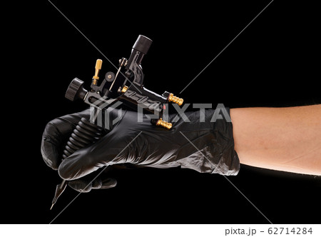 Tattoo machine in artist's hand 62714284